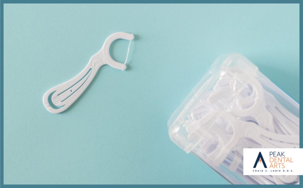 A box of white dental flossers on bright blue background. 